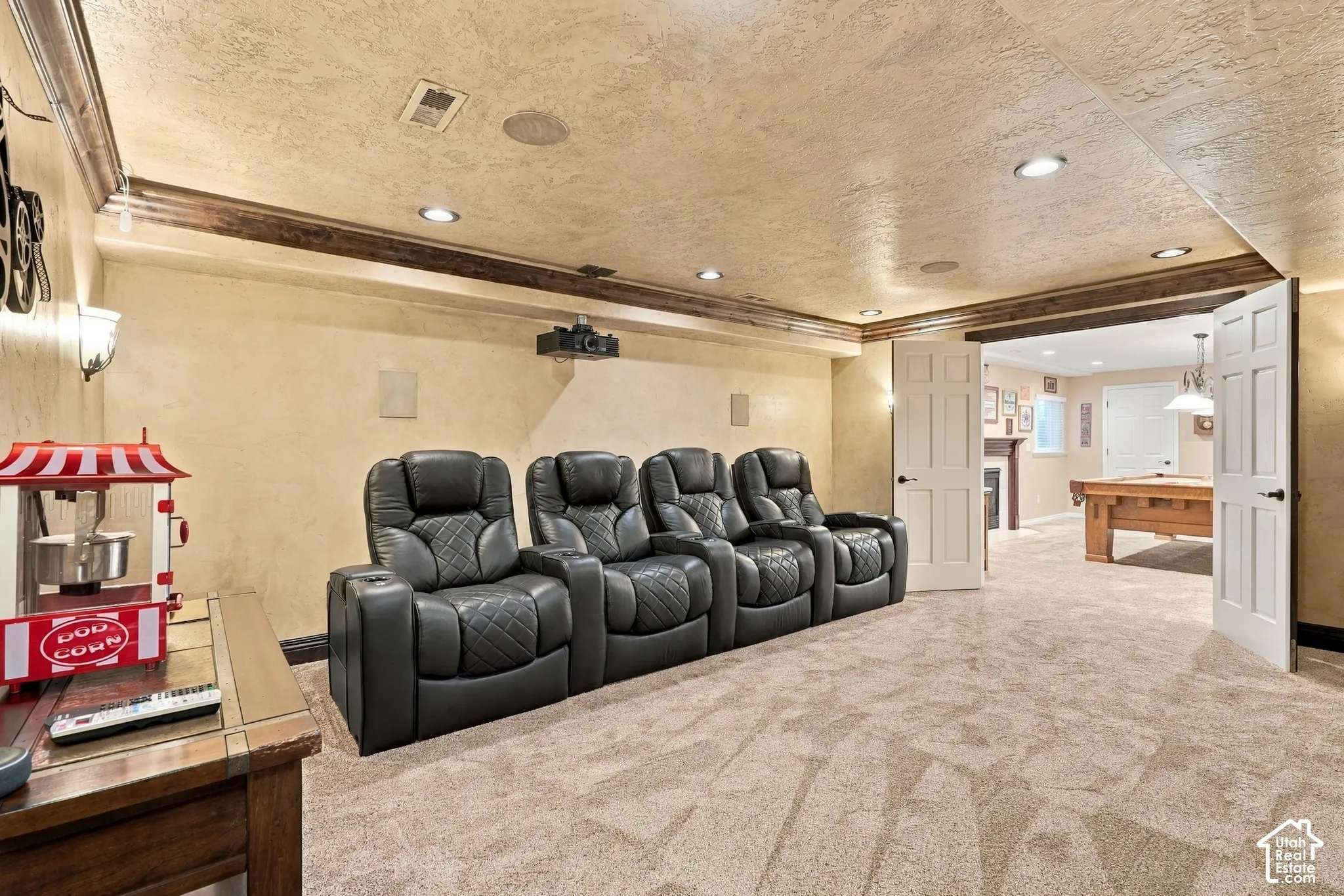 Recessed lighting, textured ceiling, decorative wood beams, sconce lighting, and a wide entryway