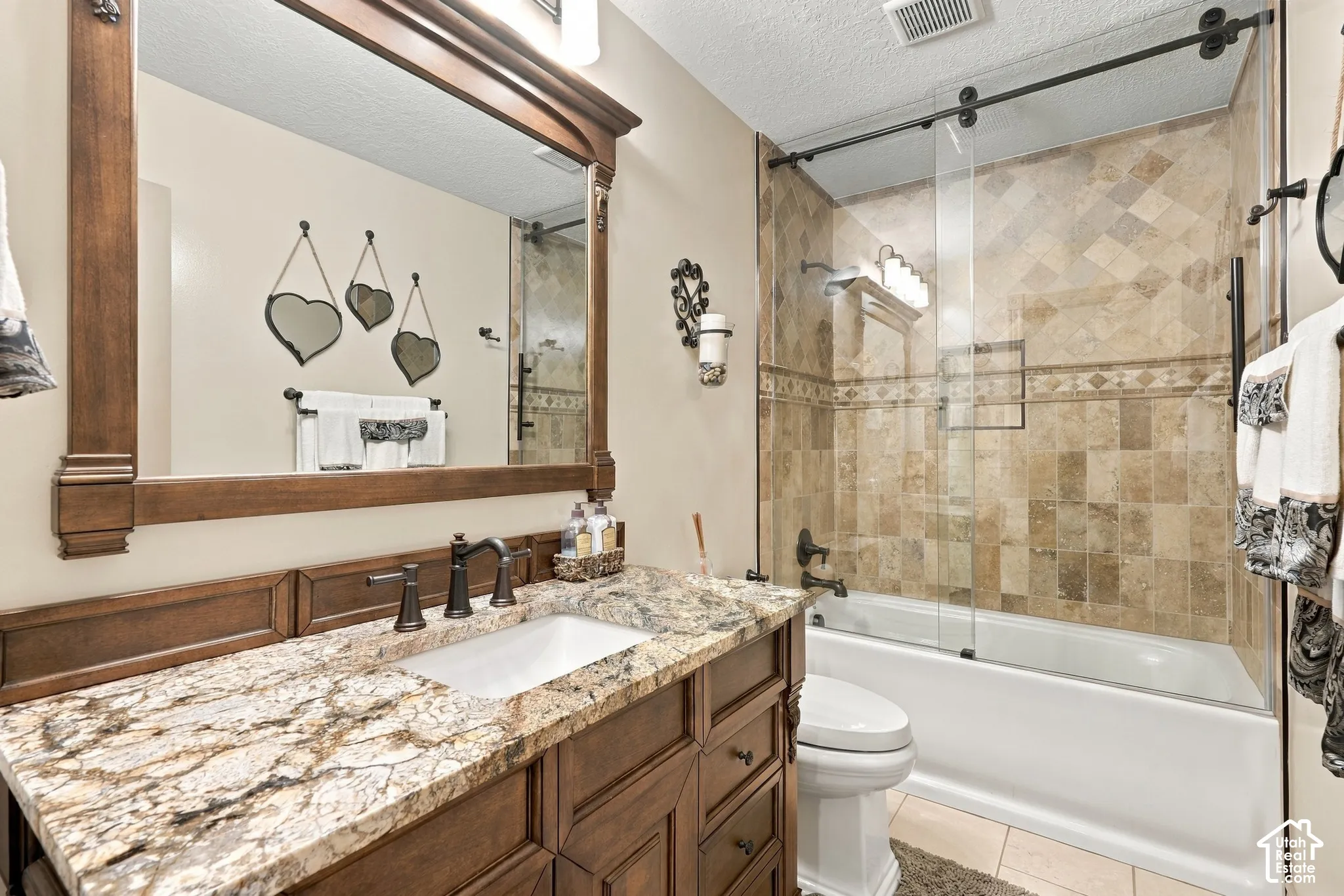 Vanity with a granite countertop, undermount sink, and dark bronze-finish fixtures