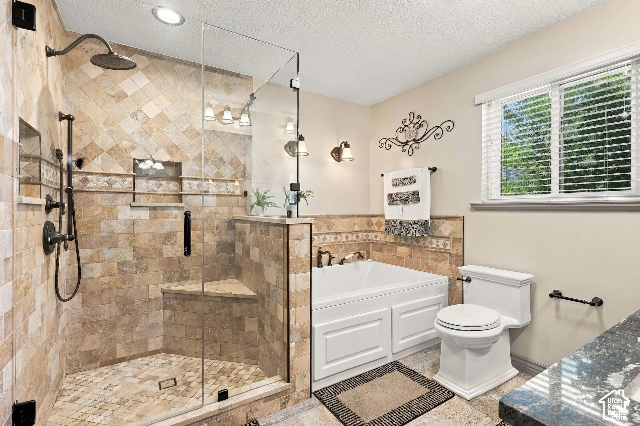 Walk-in shower with full tile surround, integrated bench, and frameless glass enclosure