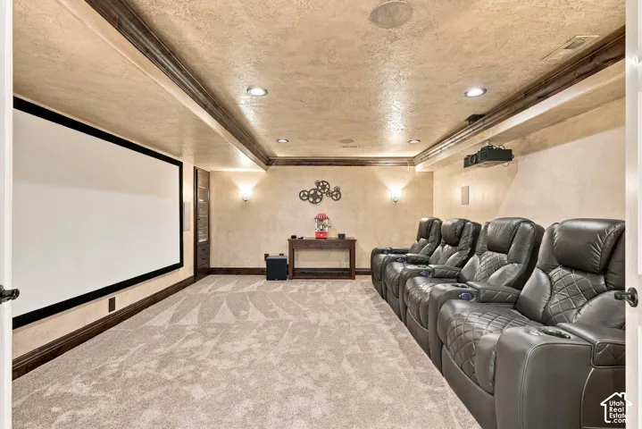 Built-in projection screen, recessed lighting, ceiling-mounted projector, wall sconces, and patterned carpeting