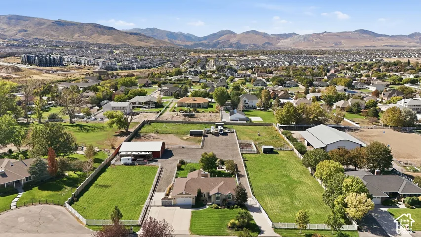 Expansive property featuring a ranch-style residence, white picket fence, large barn, and surrounding green spaces