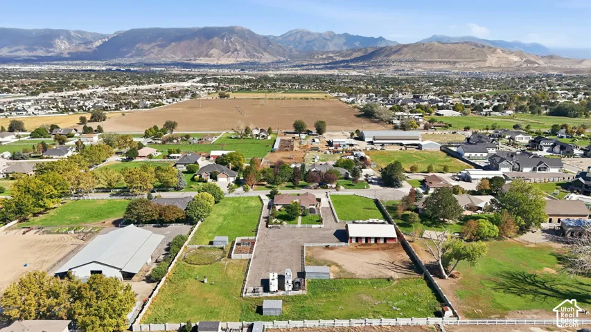 Expansive property featuring a main residence, two outbuildings, open land, and mountain scenery