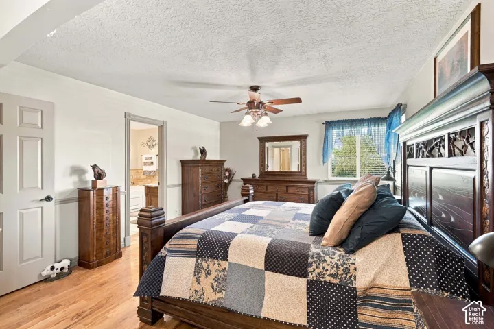 Wood-finish flooring, ceiling fan with integrated lighting, and a window for natural light
