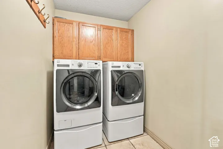 Laundry area featuring built-in cabinetry and tile flooring