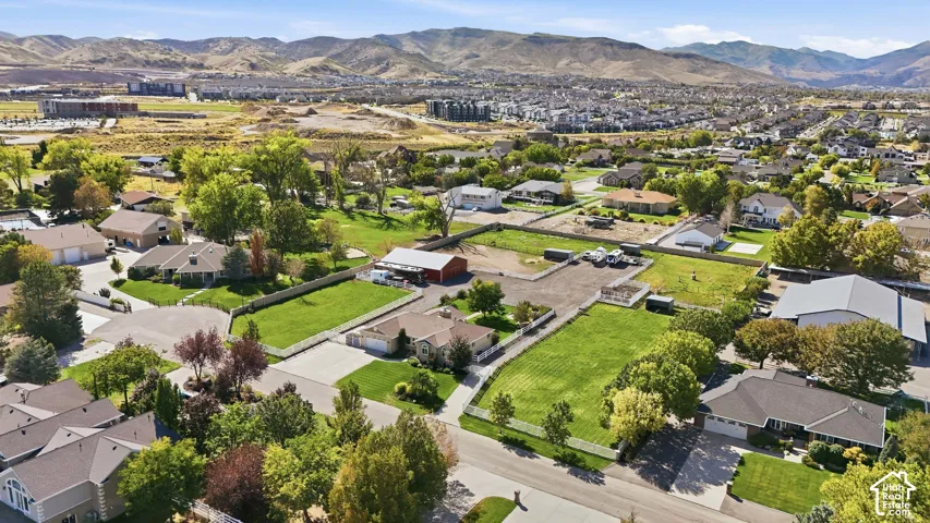 Expansive property featuring a flat, manicured lawn, white picket fencing, and mature trees