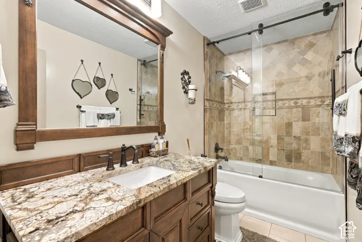Vanity with a granite countertop, undermount sink, and dark bronze-finish fixtures
