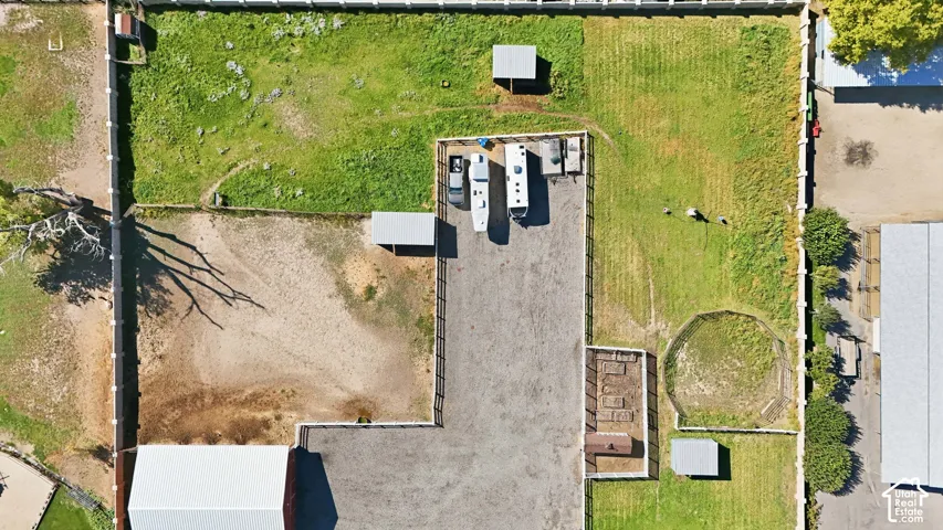 Expansive property featuring varied terrain, a large paved area, and multiple fenced sections
