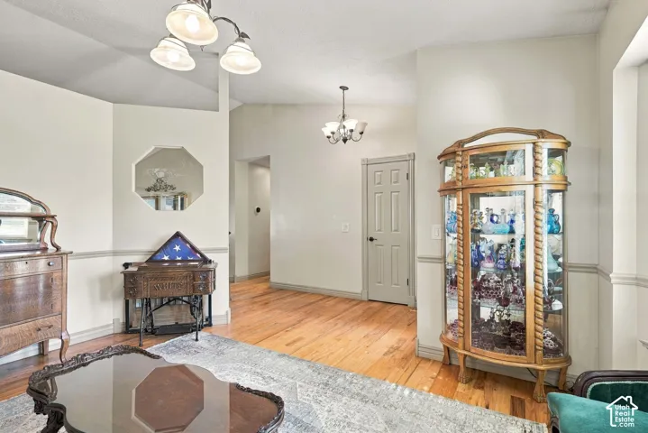 Wood-finish flooring throughout, vaulted ceiling, decorative wall cut-out, and a two-panel interior door