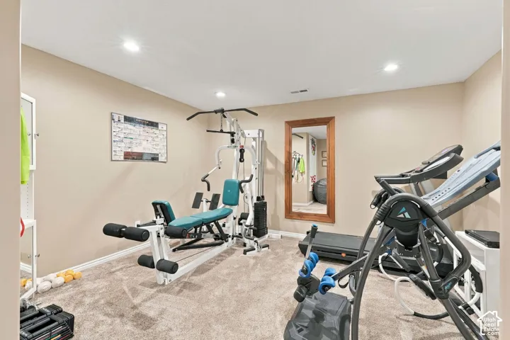 Carpeted room with recessed lighting and a large framed wall mirror