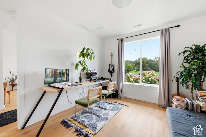 Hardwood flooring, white walls, large window with outdoor landscape, recessed lighting, and a ceiling-mounted light fixture