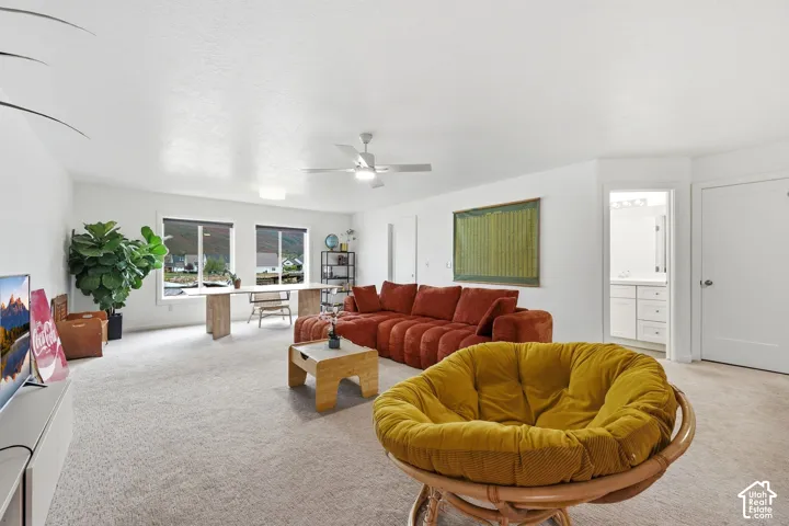 Light-toned carpeting, ample recessed lighting, and a ceiling fan with integrated lighting