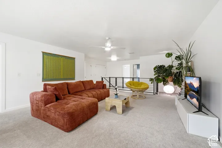Carpeted flooring, white walls, and a white ceiling fan