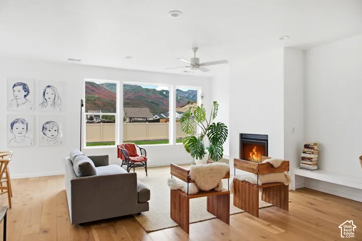 Hardwood-finish flooring throughout, modern fireplace, recessed lighting, ceiling fan, and large windows with mountain scenery
