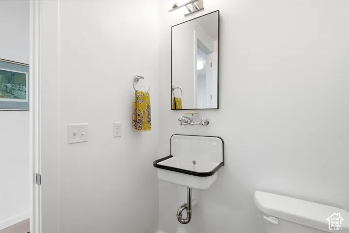 Wall-mounted basin sink with a black edge, chrome faucet, and rectangular mirror