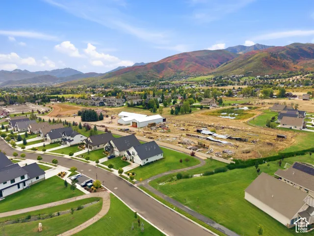 Mountain backdrop with varied autumn foliage, residential neighborhood, paved streets, and green spaces