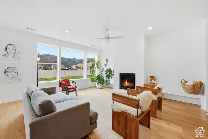 Hardwood flooring, recessed lighting, and a modern fireplace with a black surround