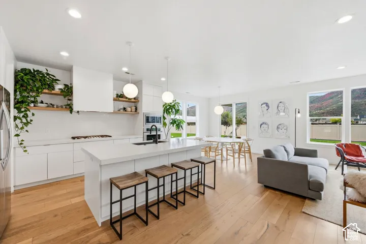 Open-concept living space with wood-finish flooring, recessed lighting, and large windows