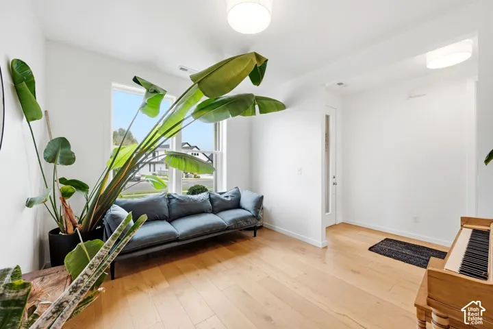 Hardwood flooring, ample natural light, recessed lighting, white walls, and a white door with frosted glass panel