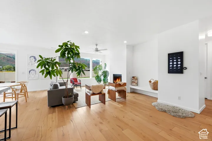 Hardwood flooring, recessed lighting, built-in fireplace, ceiling fan, and large windows