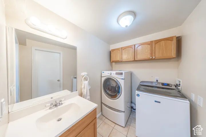 Laundry area featuring a vanity with an integrated sink, wall-mounted mirror, overhead lighting, and wood-finish cabinetry