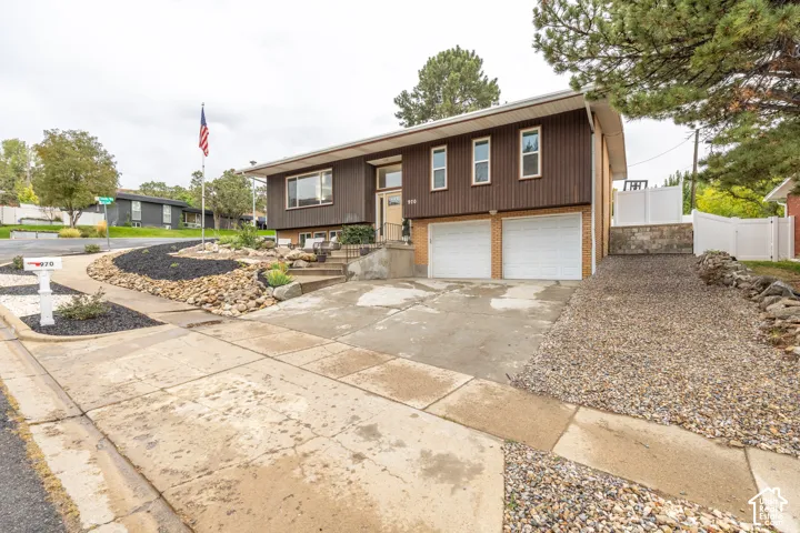 Split-level residence featuring a brown vertical siding facade and a two-car attached garage