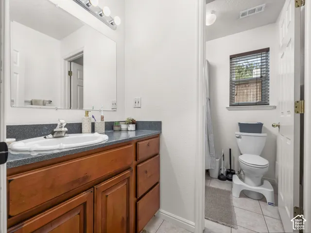 Wood-finish vanity with a dark countertop and integrated sink