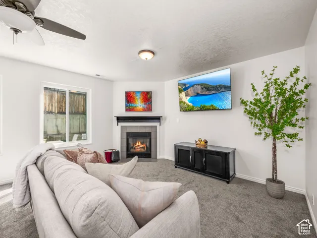 Built-in fireplace with mantel, ceiling fan, recessed lighting, and a large window
