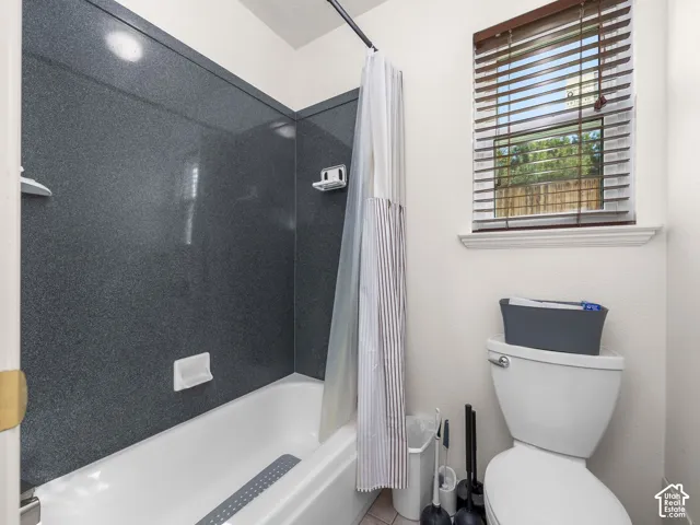 Tub and shower combination with dark-toned surround
