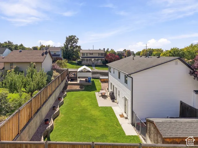 Expansive lawn area, concrete patio, retaining wall, wood fencing, and a shed