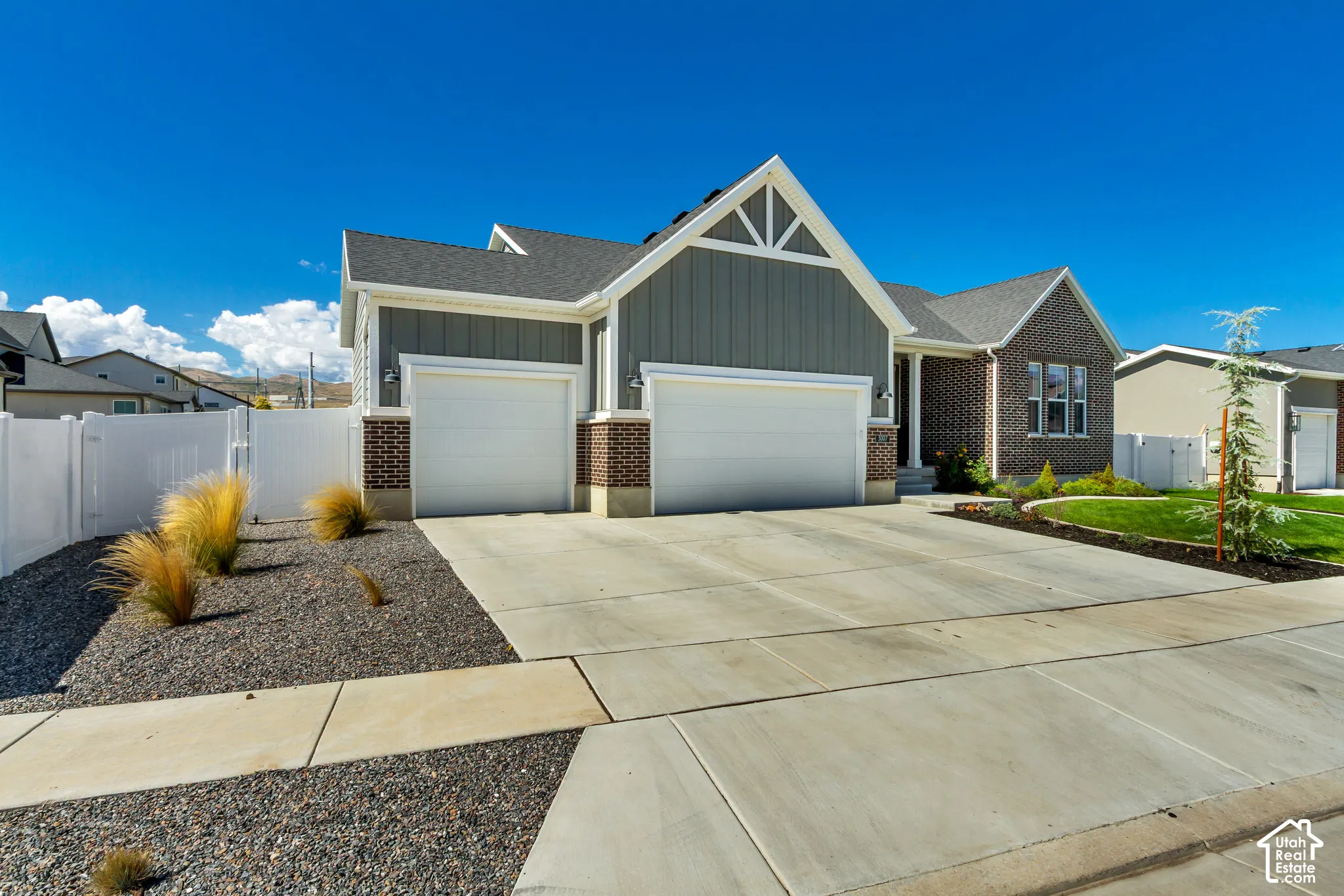 Exterior featuring a combination of brick and vertical siding, a paved driveway, and an attached garage