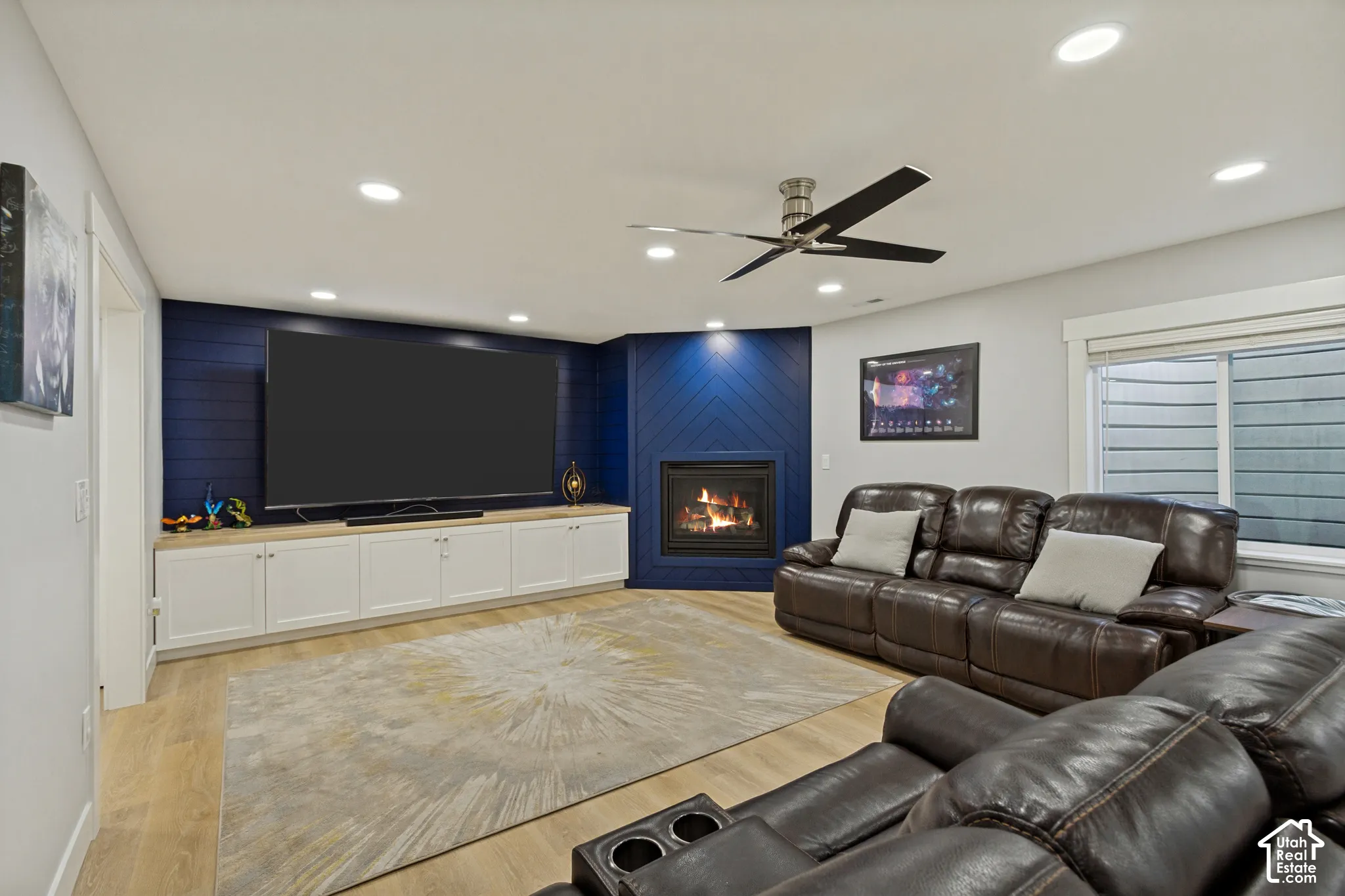 Recessed lighting, LVP flooring, built-in cabinetry with light-toned countertop, corner fireplace, and ceiling fan