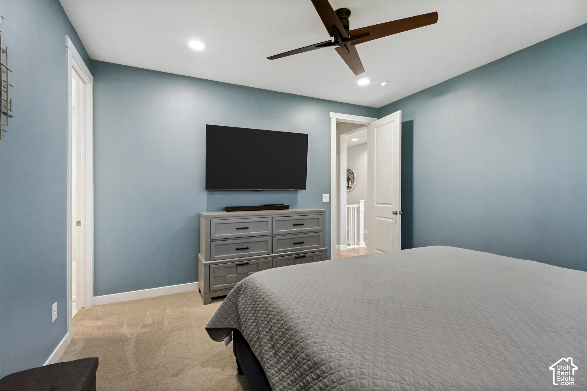 Ceiling fan with wooden blades, recessed lighting, and light blue wall finish