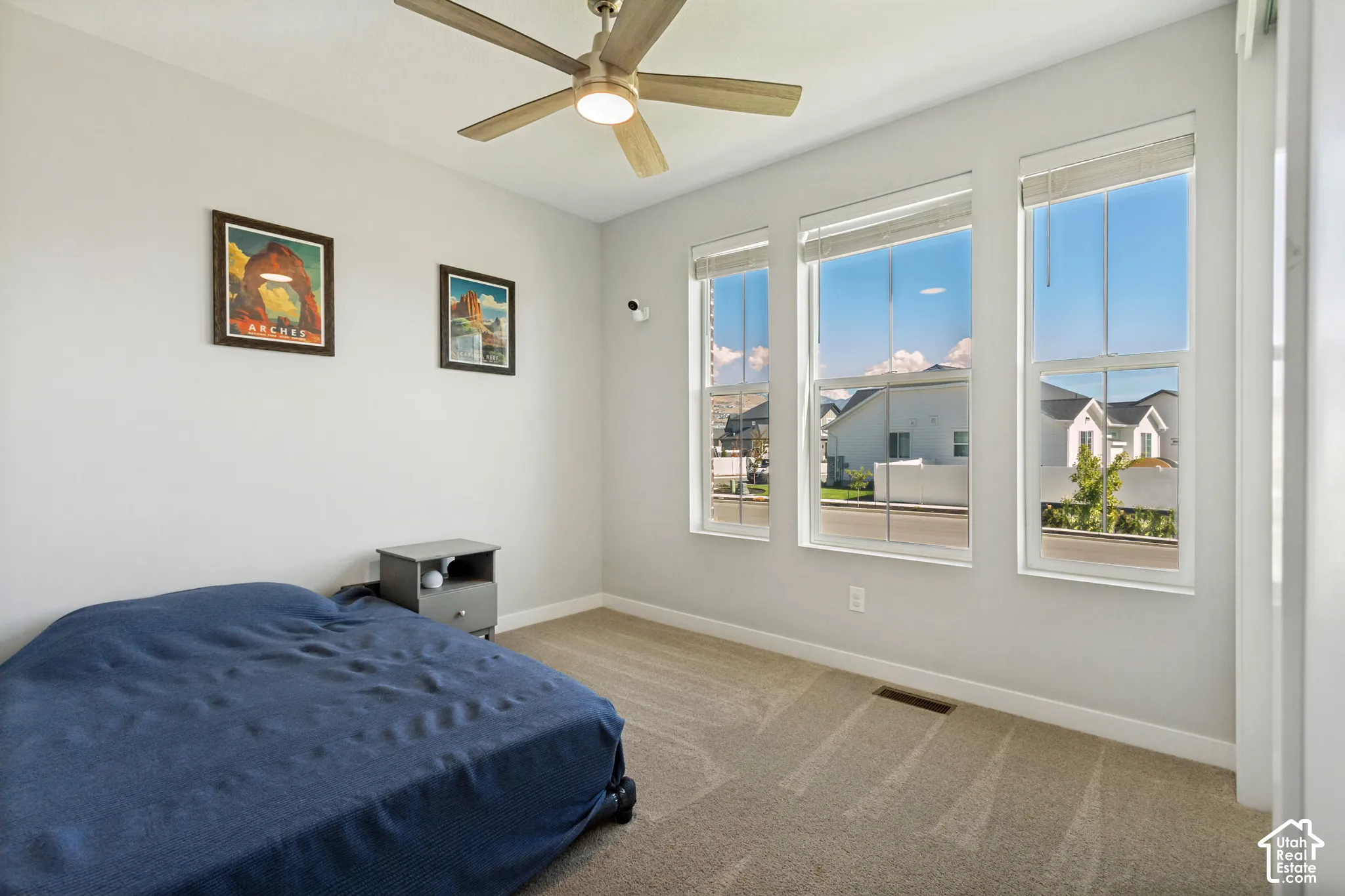 Recessed lighting with a ceiling fan, light-toned walls, three vertical windows, and carpeting