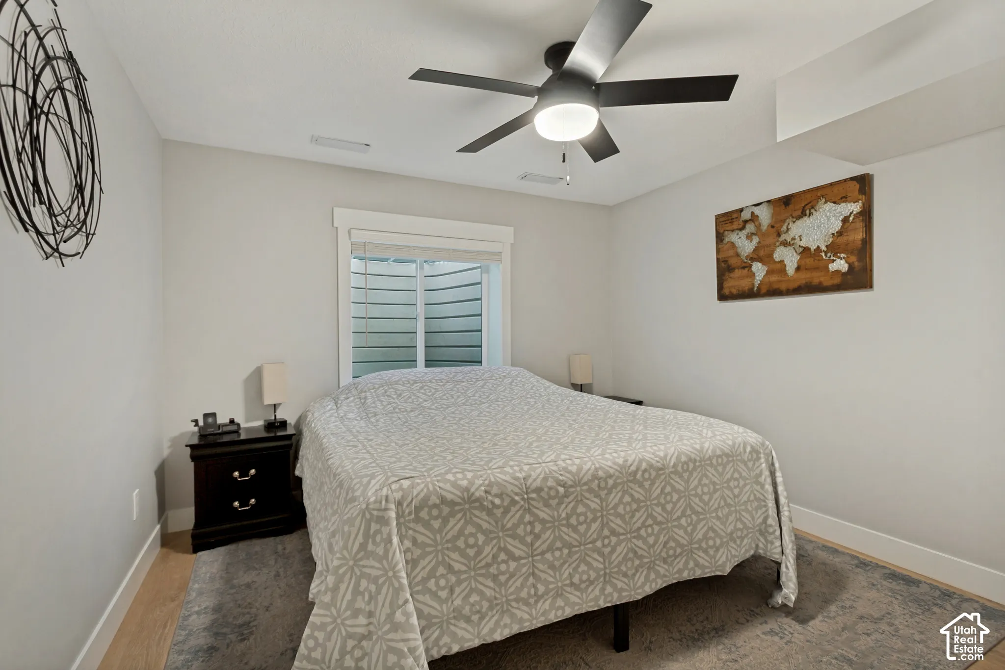 LVP flooring with a partial area rug, a window with white trim, and a ceiling fan with integrated lighting