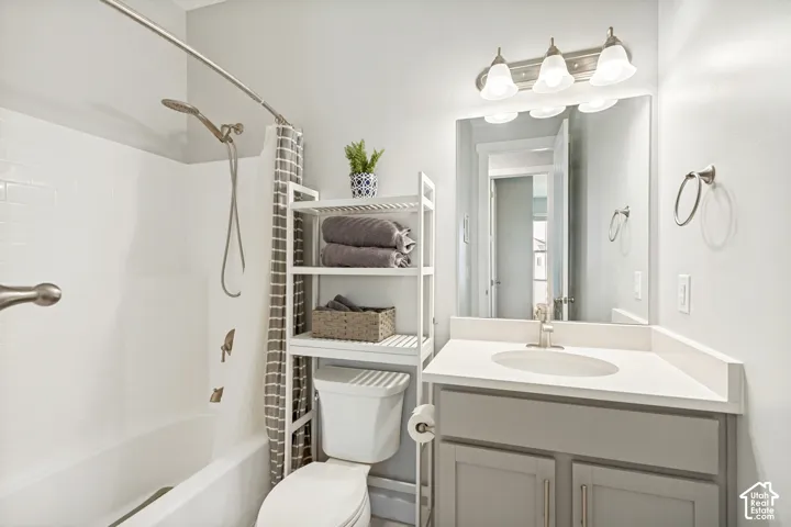 Vanity with integrated sink and countertop, brushed nickel faucet, large wall mirror, and three-light fixture