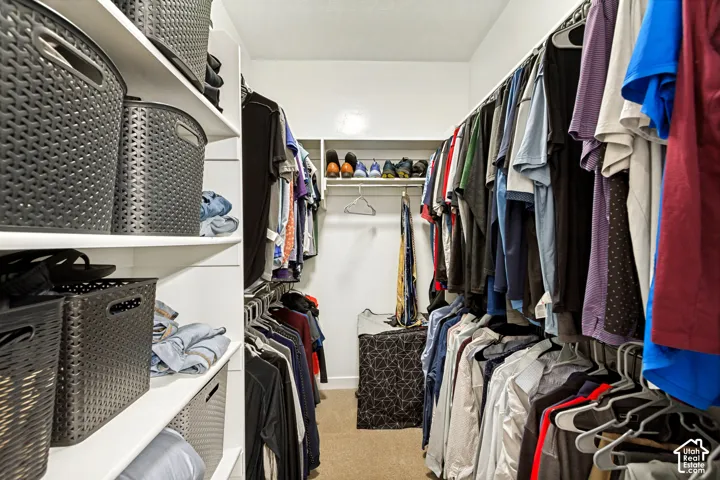 Walk-in closet featuring built-in shelving, multiple hanging rods, and recessed lighting