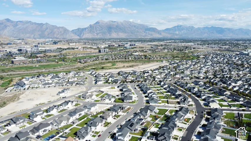 Extensive residential development with a mountain backdrop, featuring a mix of established homes and new construction
