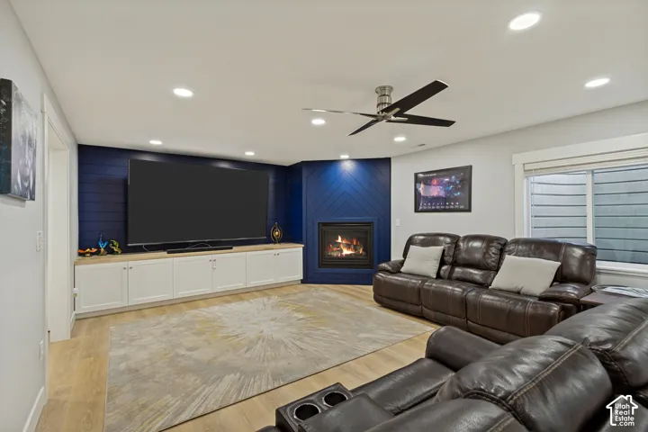 Recessed lighting, LVP flooring, built-in cabinetry with light-toned countertop, corner fireplace, and ceiling fan