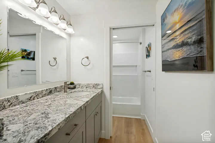 Double vanity featuring a light-toned granite countertop, undermount sinks, and brushed nickel faucets