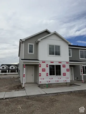 Two-story residence featuring light gray and white vertical siding, white trim, and a gabled roofline