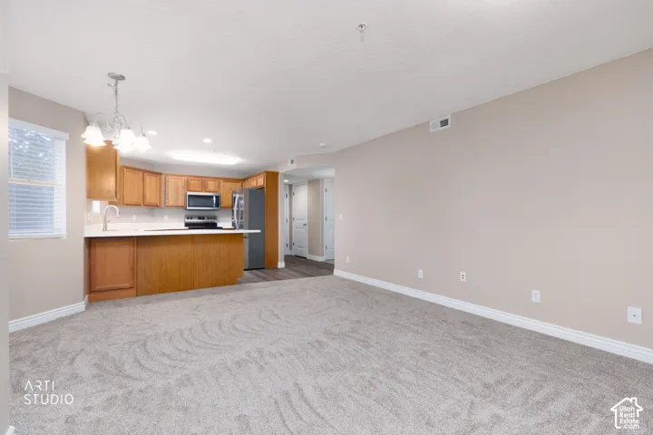 Kitchen featuring wood cabinetry, stainless steel appliances, a white countertop, and a peninsula with seating space