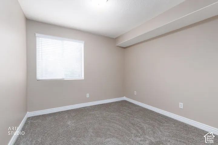 Neutral-toned walls complement the textured gray carpeting