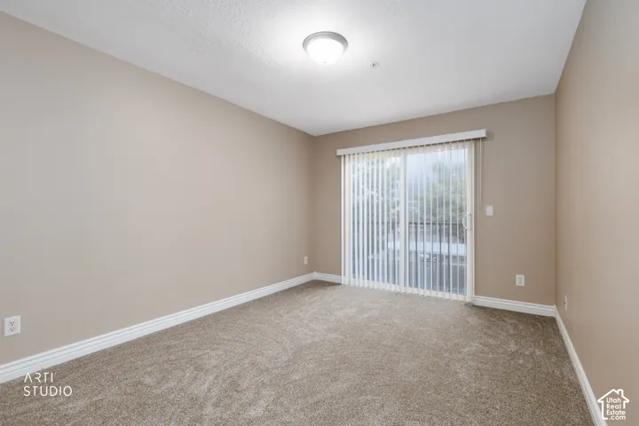 Light-colored walls, neutral-toned carpet flooring, white trim, and a sliding glass door with vertical blinds