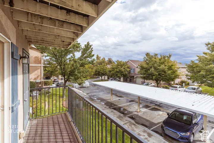 Private balcony with a dark metal railing, offering a direct perspective of the covered parking area