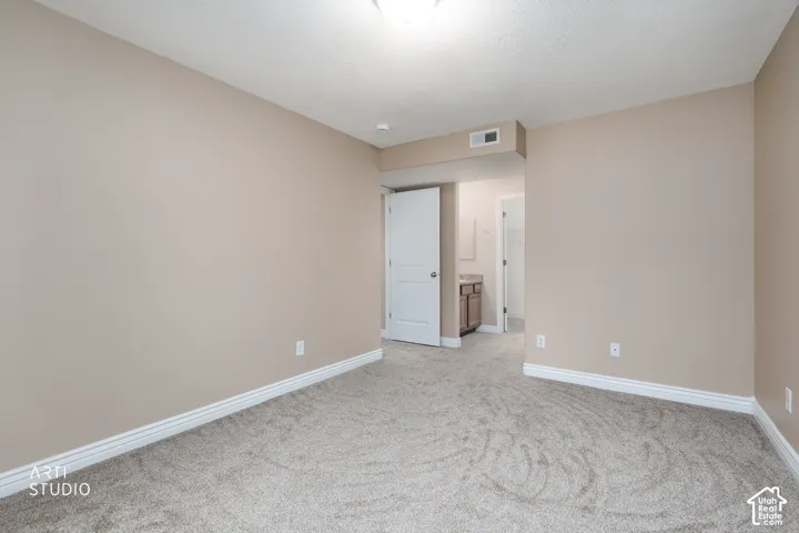 Neutral-toned walls complement the textured carpet flooring