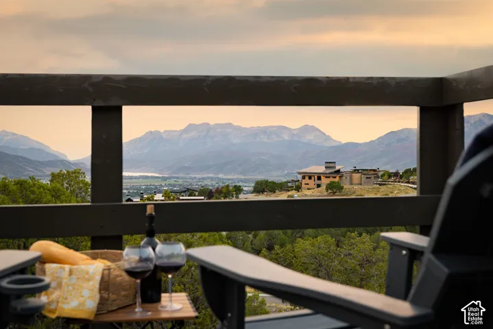 Mountain range backdrop, distant body of water, and green tree cover