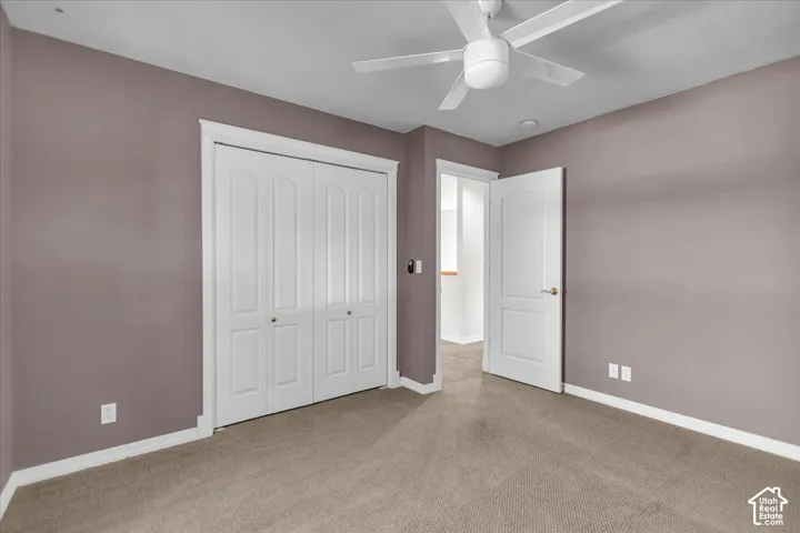 North East Bedroom with Ceiling fan, wall-to-wall carpeting, bi-fold closet doors, white trim, and a paneled door