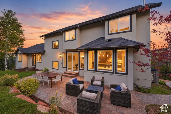 Expansive stamped concrete patio with multiple seating areas, directly accessible via sliding glass doors