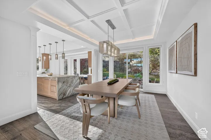 Coffered ceiling with recessed lighting, large glass doors, wood-finish flooring, full-height windows, and a waterfall island