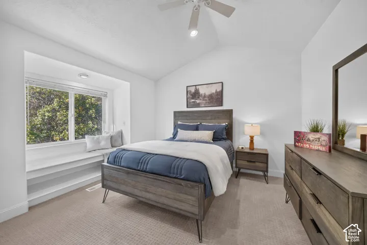 Vaulted ceiling with a ceiling fan, recessed lighting, built-in window bench, and wood-finish bedroom furniture